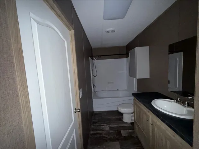 a bathroom with a sink a toilet a mirror and shower