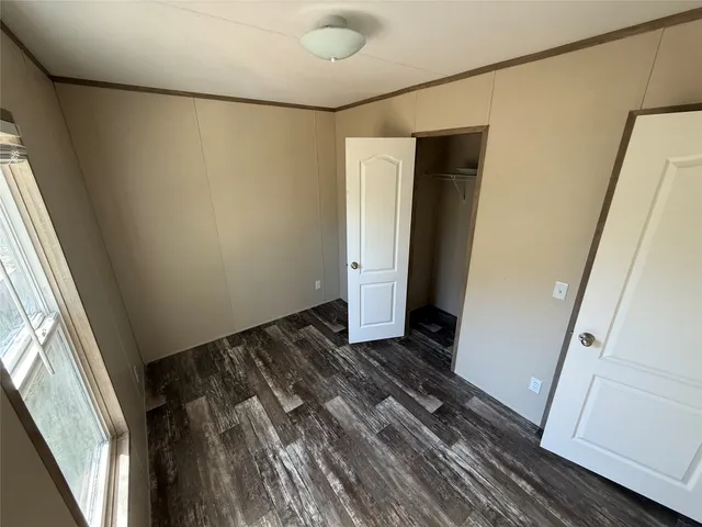 a view of a room with wooden floor and white walls