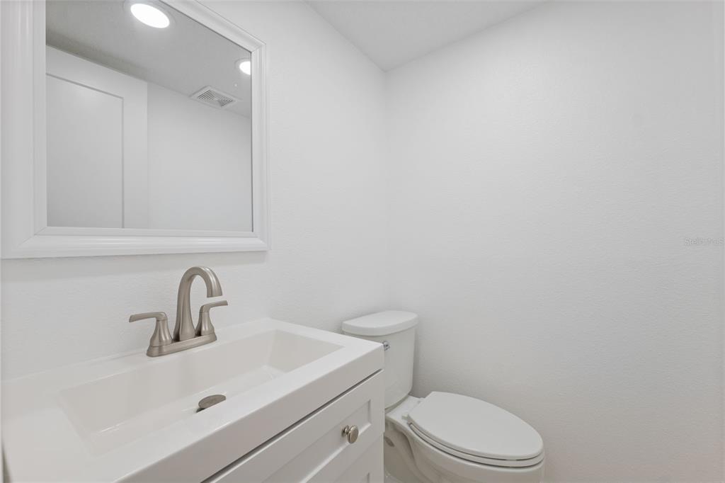 4812 Jasper Drive, Unit 105 New Port Richey, FL 34652 - Photo 17 of 63 a bathroom with a sink a toilet and mirror