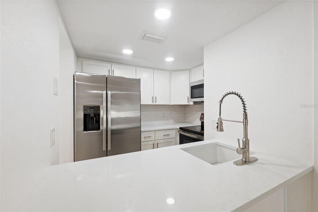 4812 Jasper Drive, Unit 105 New Port Richey, FL 34652 - Photo 19 of 63 a kitchen with a refrigerator sink and cabinets
