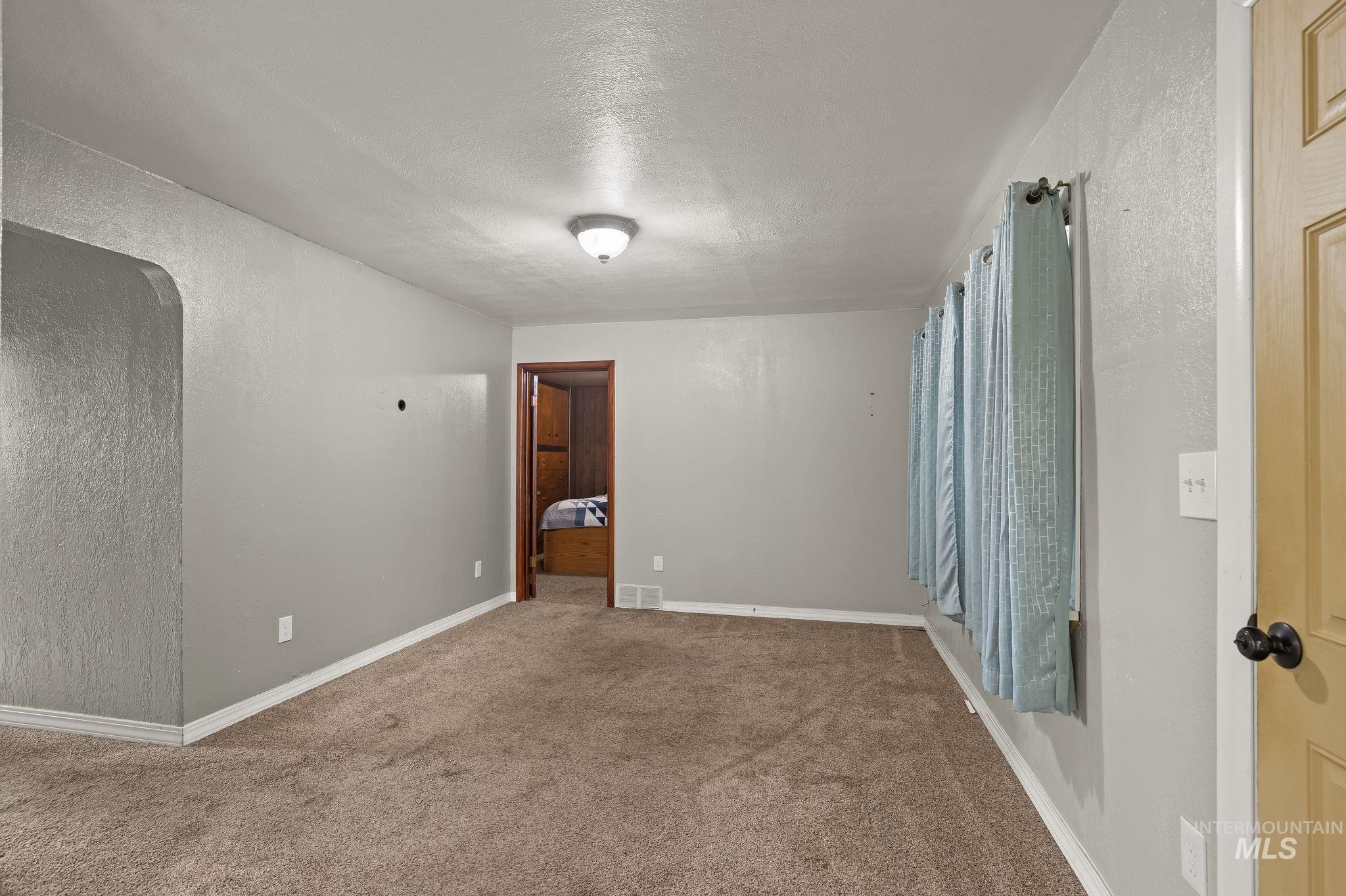 2255 Appleside Boulevard Clarkston, WA 99403 - Photo 9 of 41 Carpeted living area featuring light gray wall tones, white baseboards, and a semi-flush mount ceiling light
