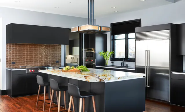 a kitchen with stainless steel appliances dining table chairs and wooden floor