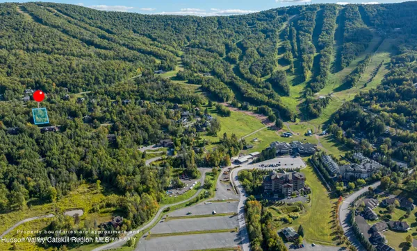 an aerial view of residential house with outdoor space and trees all around