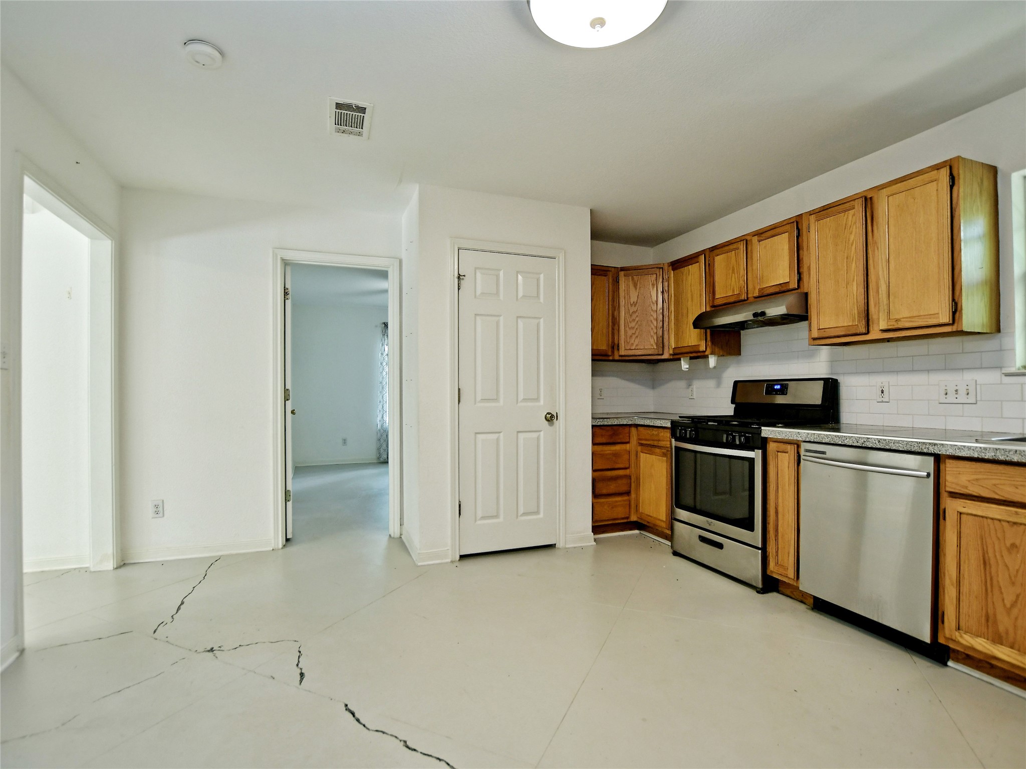 4604 Red River Street, Unit A Austin, TX 78751 - Photo 5 of 15 U-shaped kitchen featuring wood cabinetry, stainless steel range and dishwasher, and a white subway tile backsplash