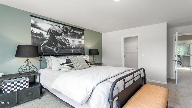 a bedroom with a bed a chair and a large window