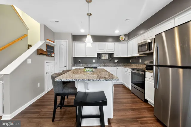 a kitchen with kitchen island granite countertop a center island and stainless steel appliances