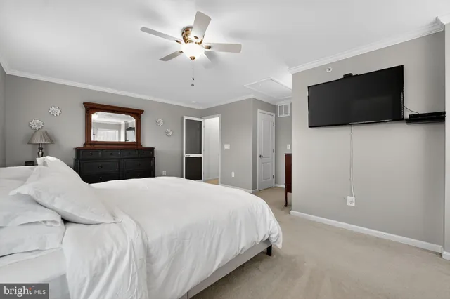 a bedroom with a bed a flat screen tv and a chandelier