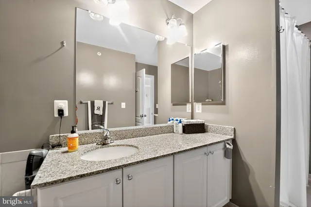 a bathroom with a granite countertop sink and a mirror