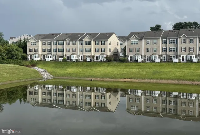 a view of a big house with a big yard and large trees