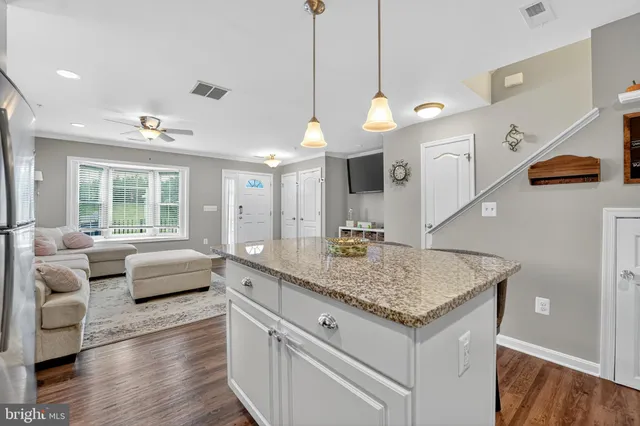 a kitchen with granite countertop living room and white cabinets