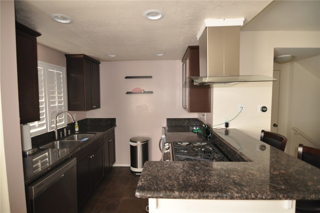 249 Alpine Street, Unit 48 Pasadena, CA 91106 - Photo 5 of 14 a kitchen with granite countertop a sink stove and cabinets