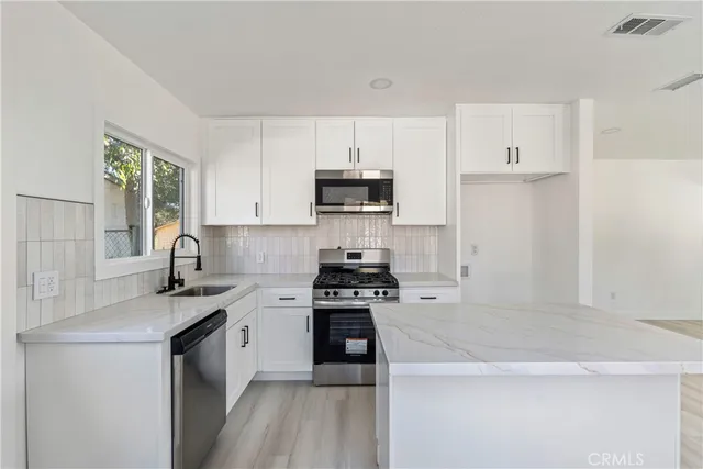 a kitchen with a stove and a white cabinets