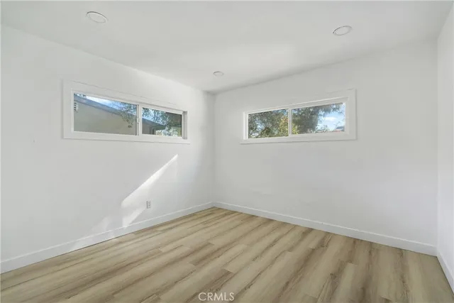 a view of empty room with wooden floor