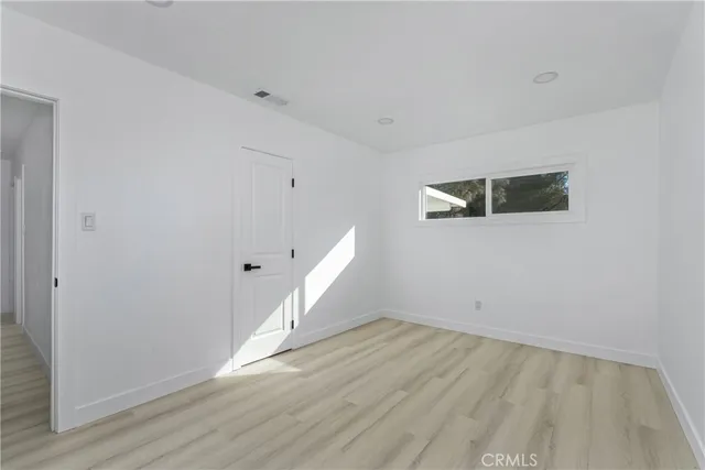 a view of a room with wooden floor and white walls