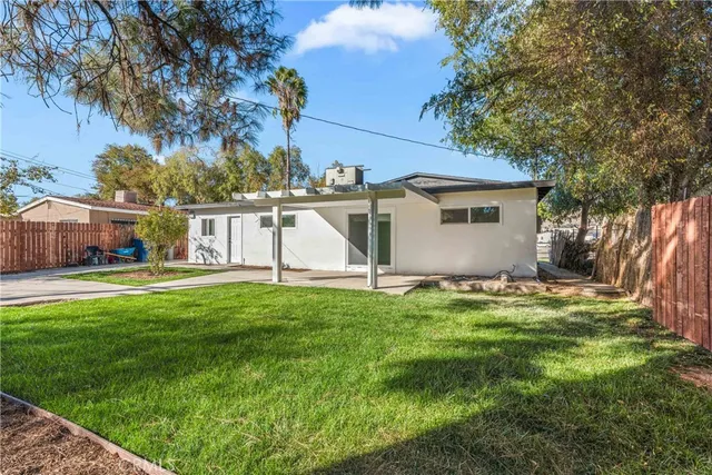 a view of a house with backyard and tree