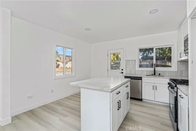 a kitchen with white cabinets and white appliances