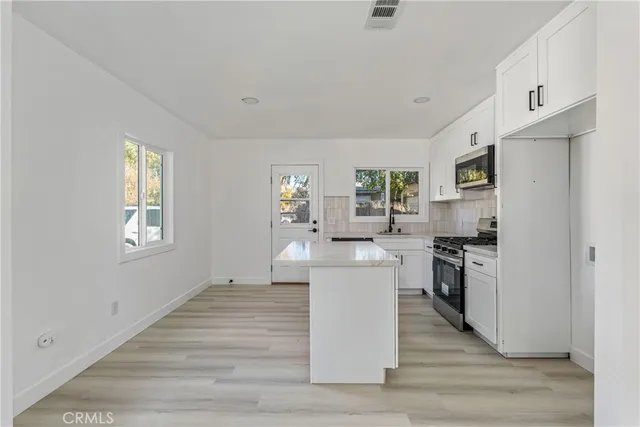 a kitchen with cabinets and wooden floor
