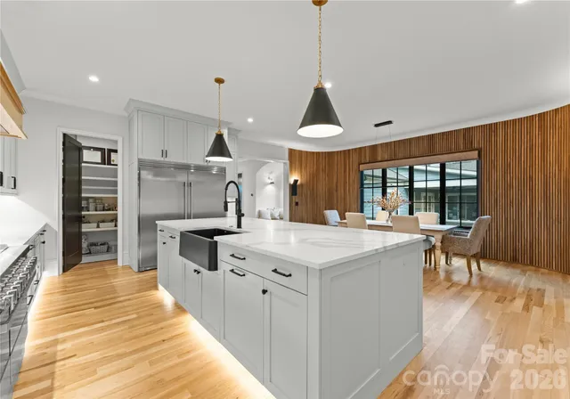 a large kitchen with kitchen island a stove a sink a island and windows