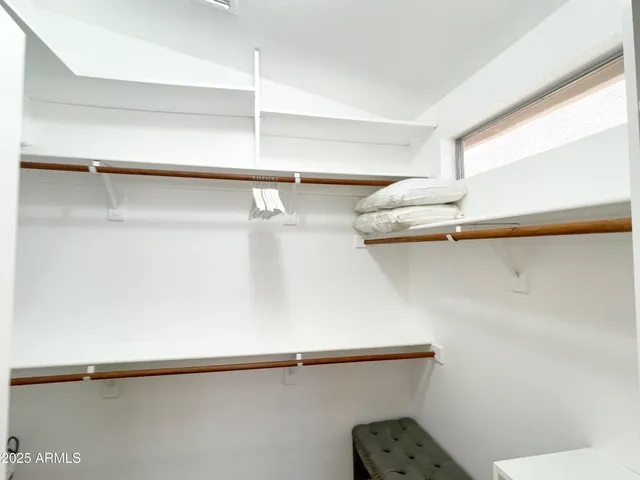 a large bed sitting in a bedroom next to a window