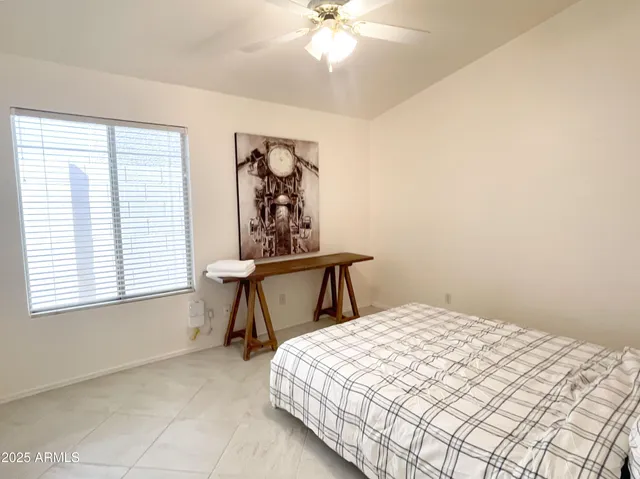 a bedroom with a bed and a painting on the wall
