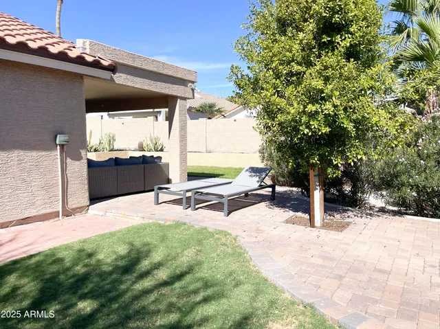 a view of a house with backyard and sitting area