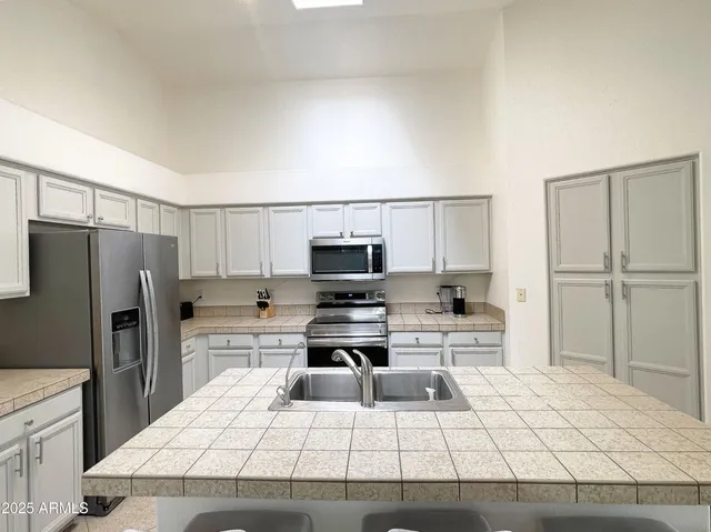 a kitchen with kitchen island a stove a sink and a refrigerator