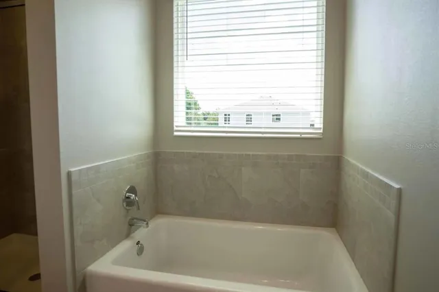 a bath tub sitting in a bathroom next to a window