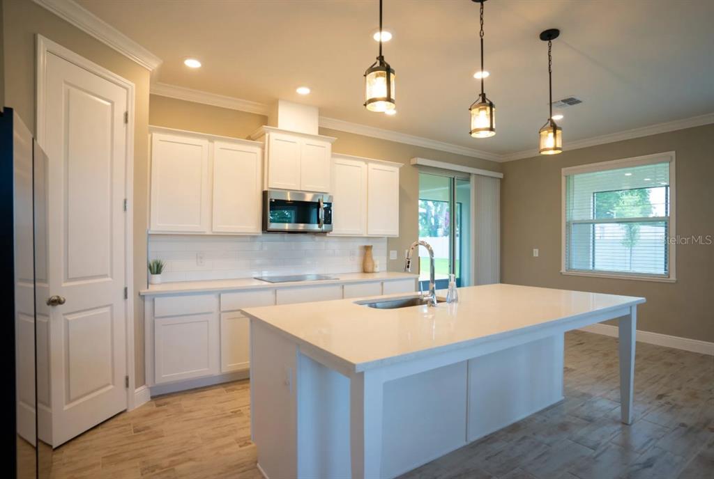 1676 Andover Rdg Drive DeLand, FL 32720 - Photo 3 of 14 a large kitchen with kitchen island a sink stainless steel appliances and cabinets