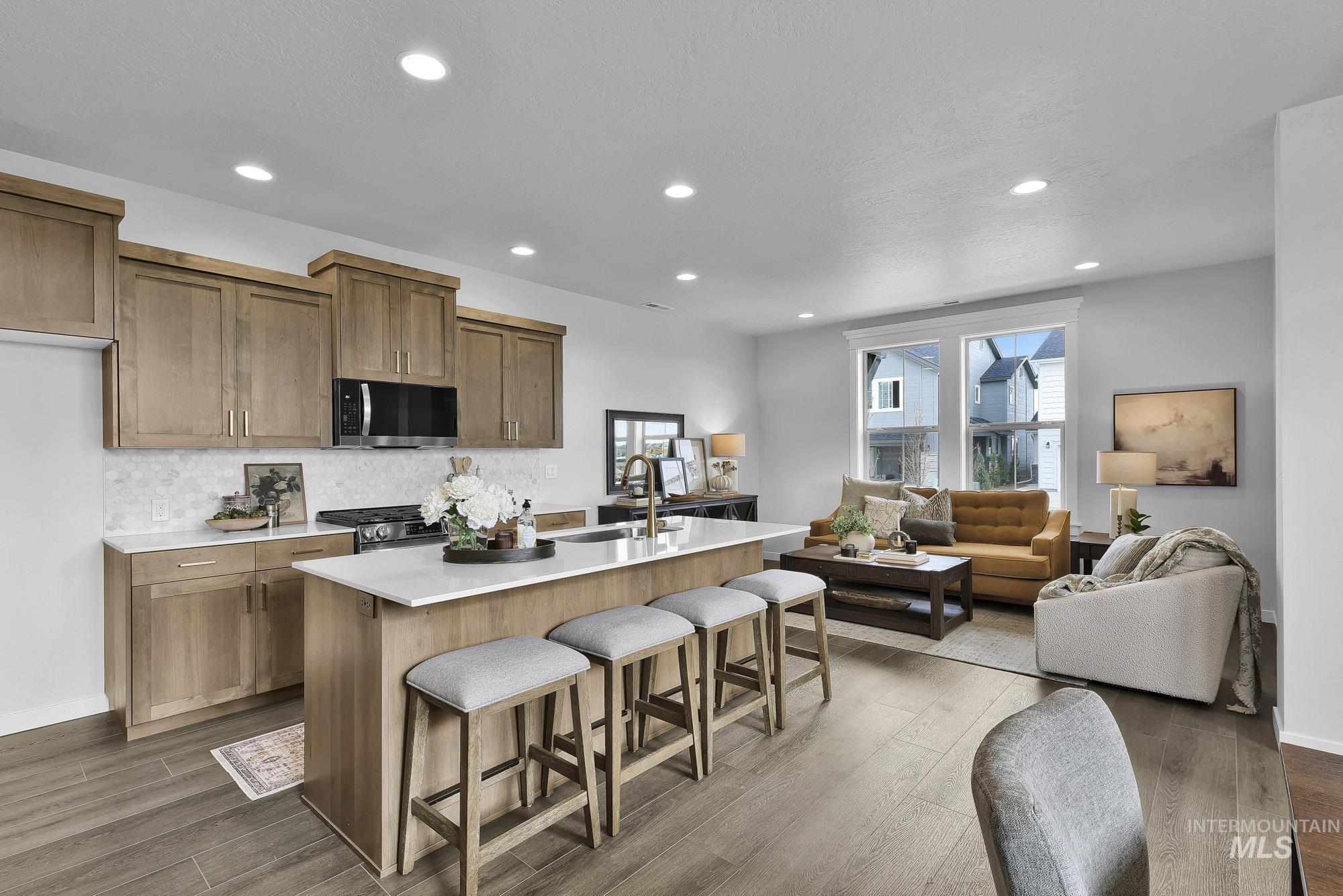 414 South Fritts Avenue Meridian, ID 83642 - Photo 20 of 21 Kitchen with a kitchen bar, a center island with sink, open floor plan, dark wood-style floors, and stainless steel appliances
