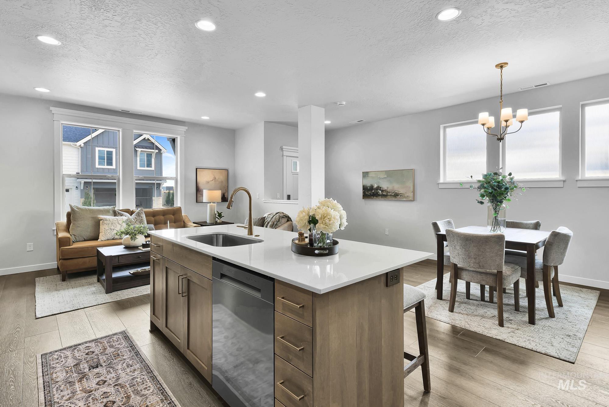 414 South Fritts Avenue Meridian, ID 83642 - Photo 21 of 21 Kitchen featuring light wood finished floors, open floor plan, stainless steel dishwasher, an island with sink, and a textured ceiling