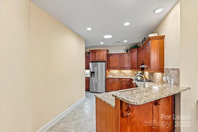 a kitchen with kitchen island granite countertop a sink stove and refrigerator