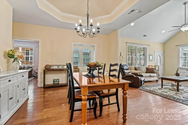 a view of a dining room with furniture a chandelier and wooden floor