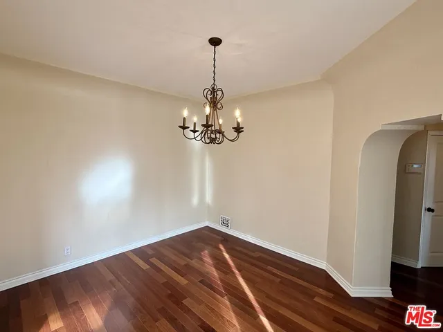 a view of a room with wooden floor chandelier and closet