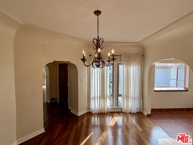 a view of a room with wooden floor and ceiling fan
