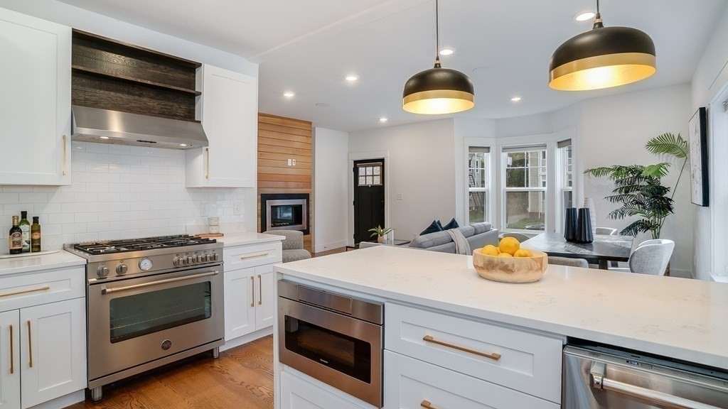 38 Chester Street, Unit 1 Somerville, MA 02144 - Photo 11 of 32 a kitchen with a stove a kitchen island a sink and cabinets