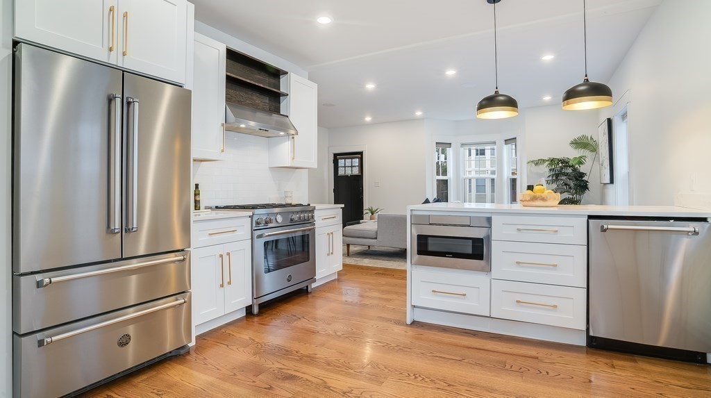 38 Chester Street, Unit 1 Somerville, MA 02144 - Photo 10 of 32 a kitchen with stainless steel appliances a stove a refrigerator and a fireplace