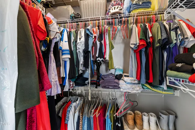 a view of walk in closet with clothes