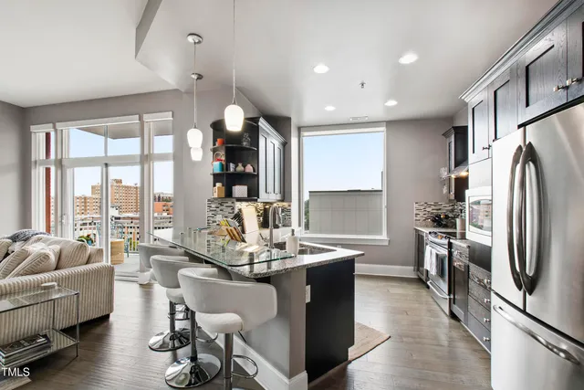 a kitchen with stainless steel appliances granite countertop a refrigerator and a stove top oven