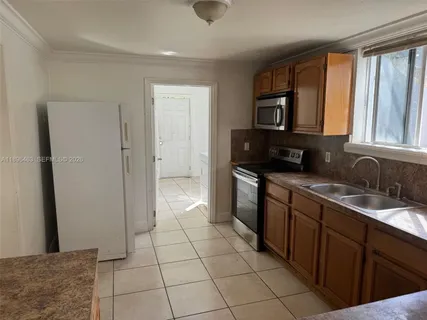 a kitchen with a sink a refrigerator and cabinets