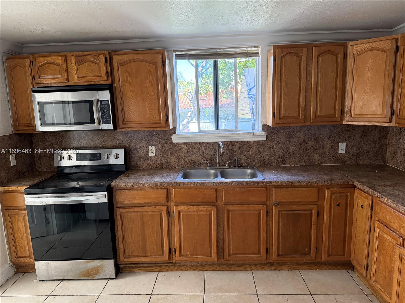 1738 Southwest 17th Street Miami, FL 33145 - Photo 23 of 29 a kitchen with stainless steel appliances granite countertop a stove sink and cabinets