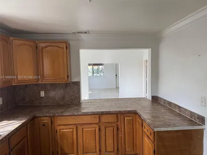 a kitchen with granite countertop a sink and cabinets