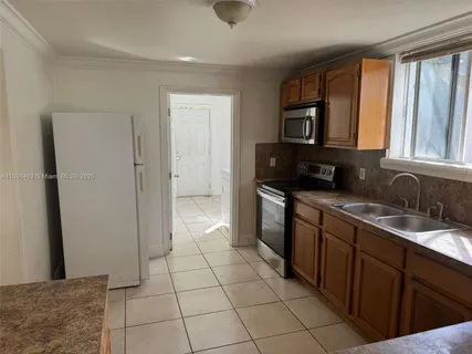 a kitchen with a sink a refrigerator and cabinets