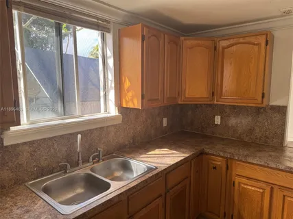 a kitchen with a sink cabinets and a window