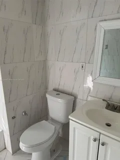 a white toilet sitting next to a bathroom sink