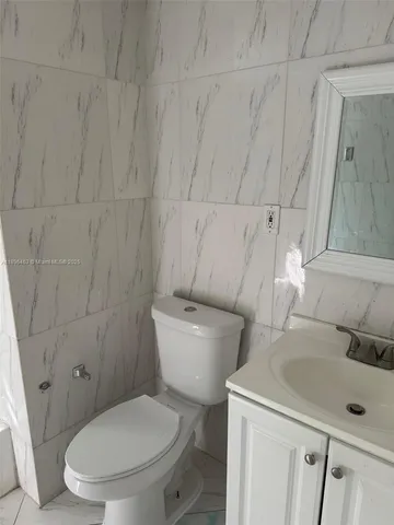 a white toilet sitting next to a bathroom sink