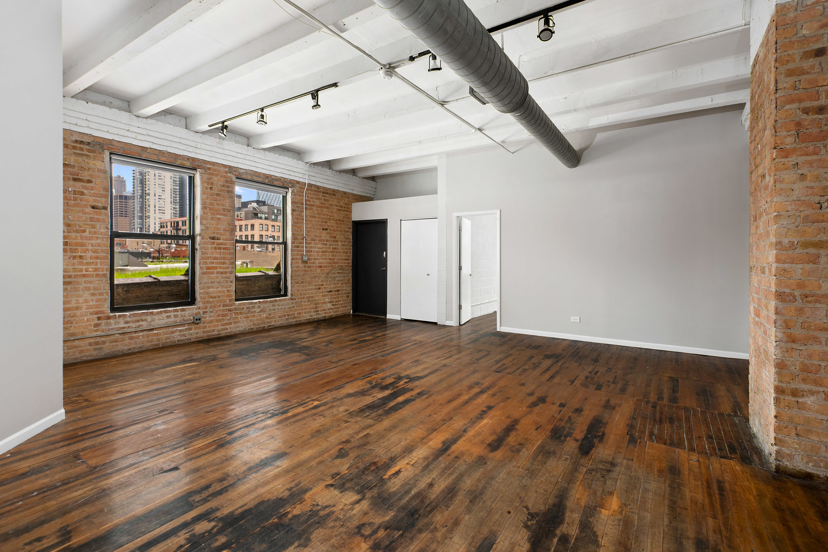 1012 West Randolph Street, Unit 3 Chicago, IL 60607 - Photo 3 of 8 an empty room with wooden floor and windows