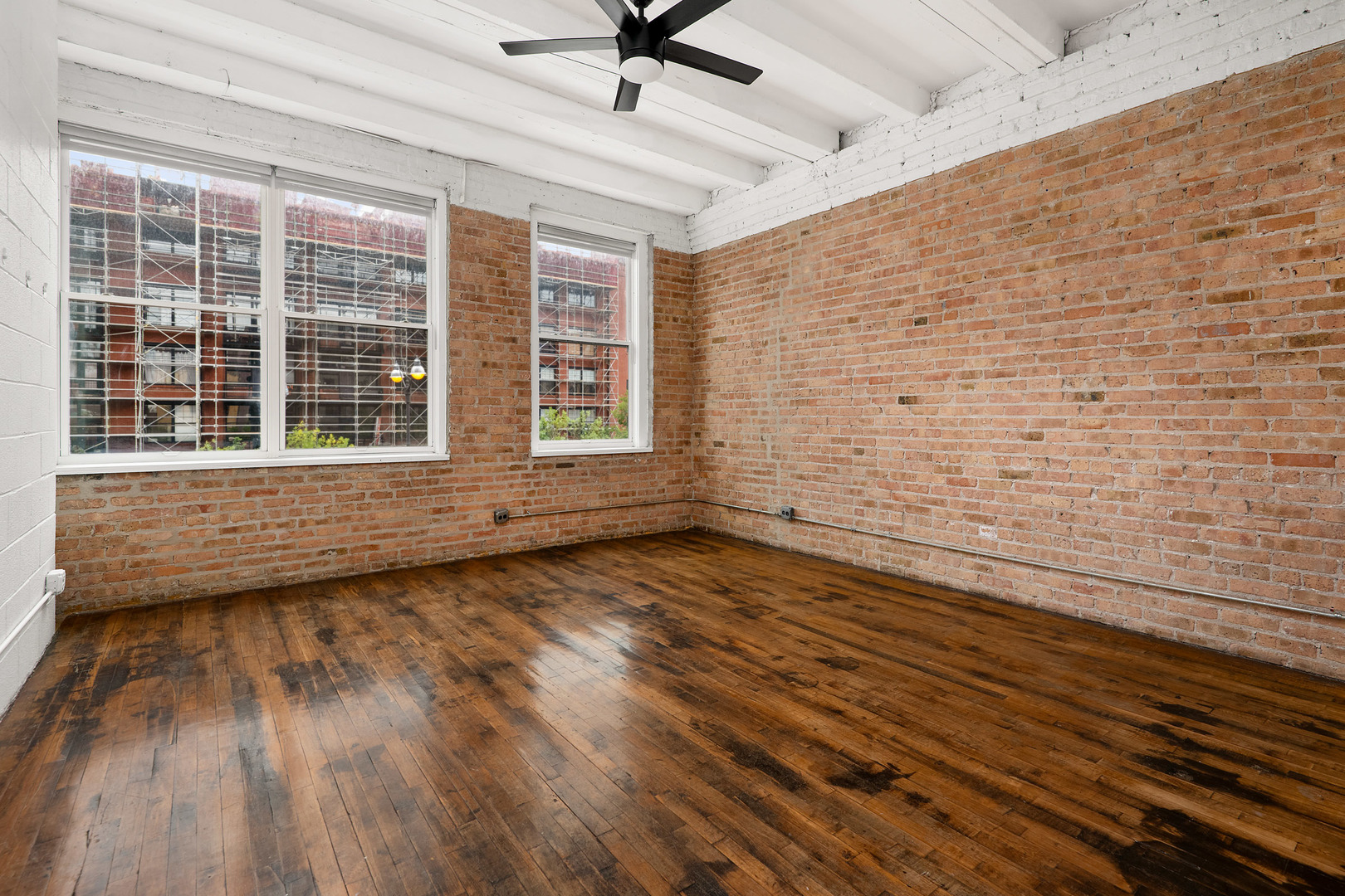 1012 West Randolph Street, Unit 3 Chicago, IL 60607 - Photo 5 of 8 a view of an empty room with a window and wooden floor