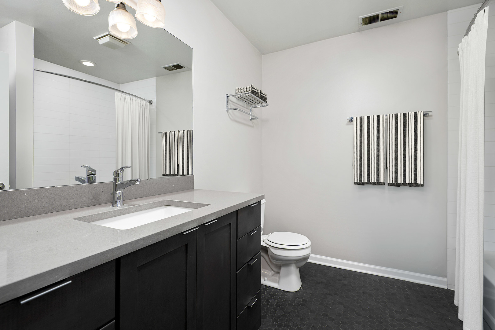 1012 West Randolph Street, Unit 3 Chicago, IL 60607 - Photo 8 of 8 a bathroom with a granite countertop sink a toilet and a mirror