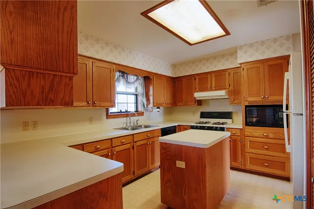 a kitchen with stainless steel appliances granite countertop a sink stove and cabinets