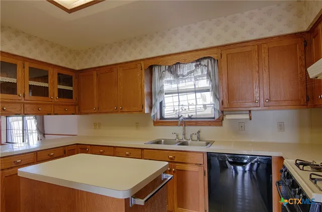 a kitchen with a sink a stove and cabinets